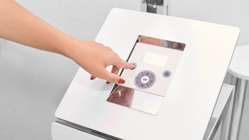 women's hand pressing a button on an aesthetic device