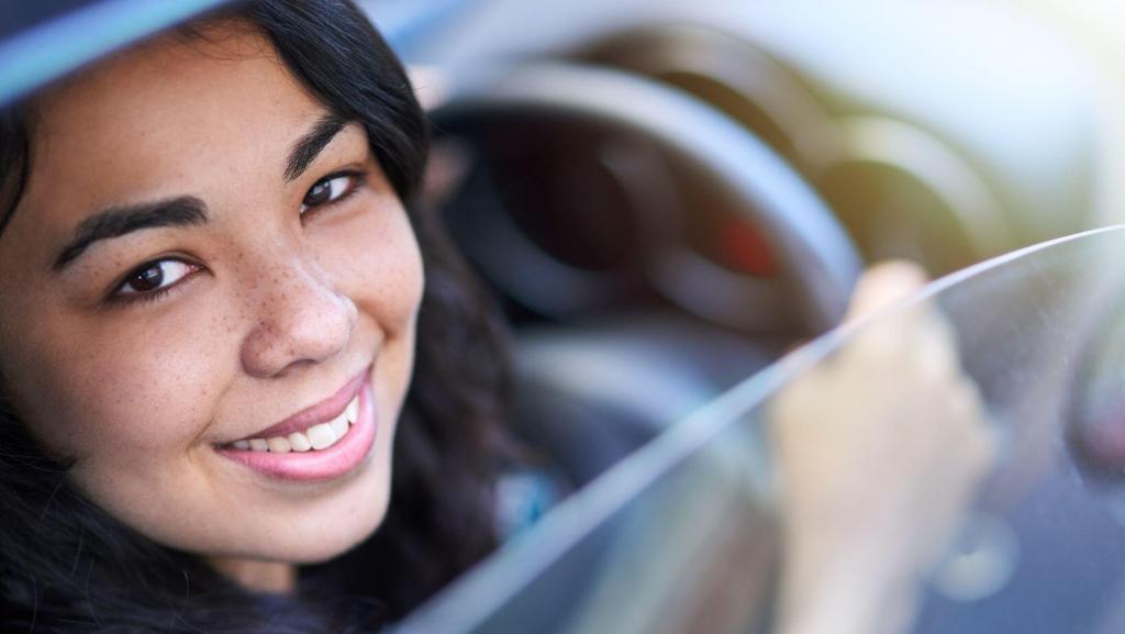 woman behind the wheel of a mobile body sculpting business smiling looking through the window