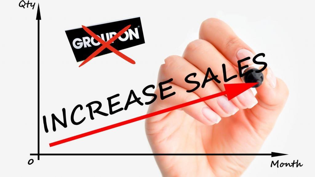 woman's hand drawing sales chart, "increase sales" with an upward arrow and in the upper left corner the Groupon logo crossed out