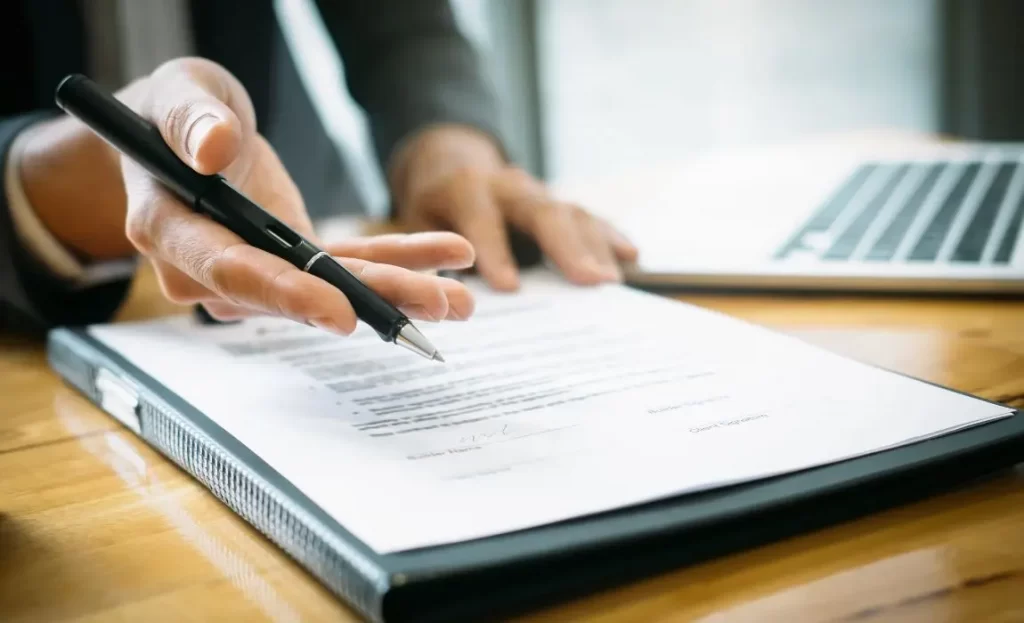 close up of hand holding a pen discussing body contouring service policies