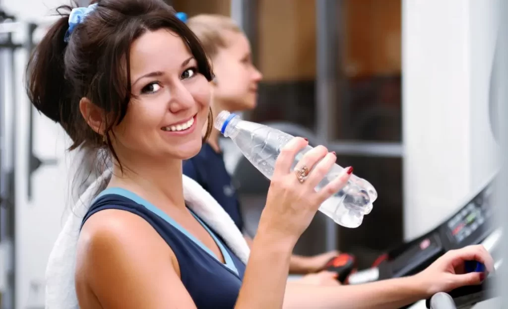 happy fitness woman with water bottle
