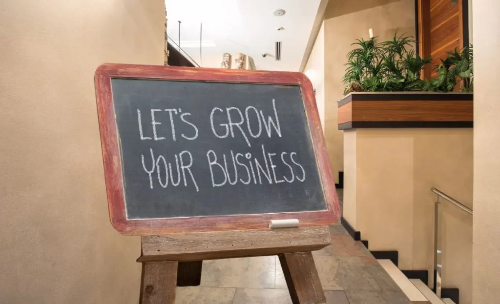 Let's grow your business written chalk board easel stand in hall of wellness center