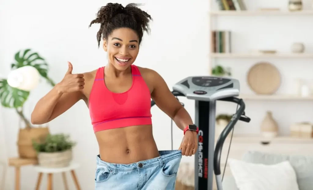 cheerful woman showing results after vibration therapy for weight loss