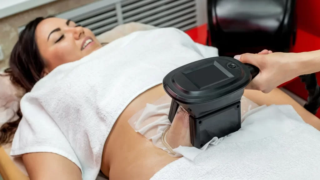woman treating abdominal area with minimal cryolipolysis (fat freezing) risks