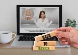 body contouring fundamentals course on a laptop screen, hand stacking back to basics blocks in front