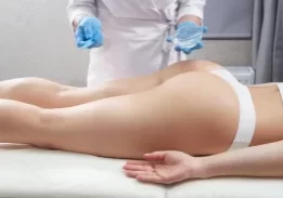 cosmetologist applying gel to client's bank end for butt enhancement formula
